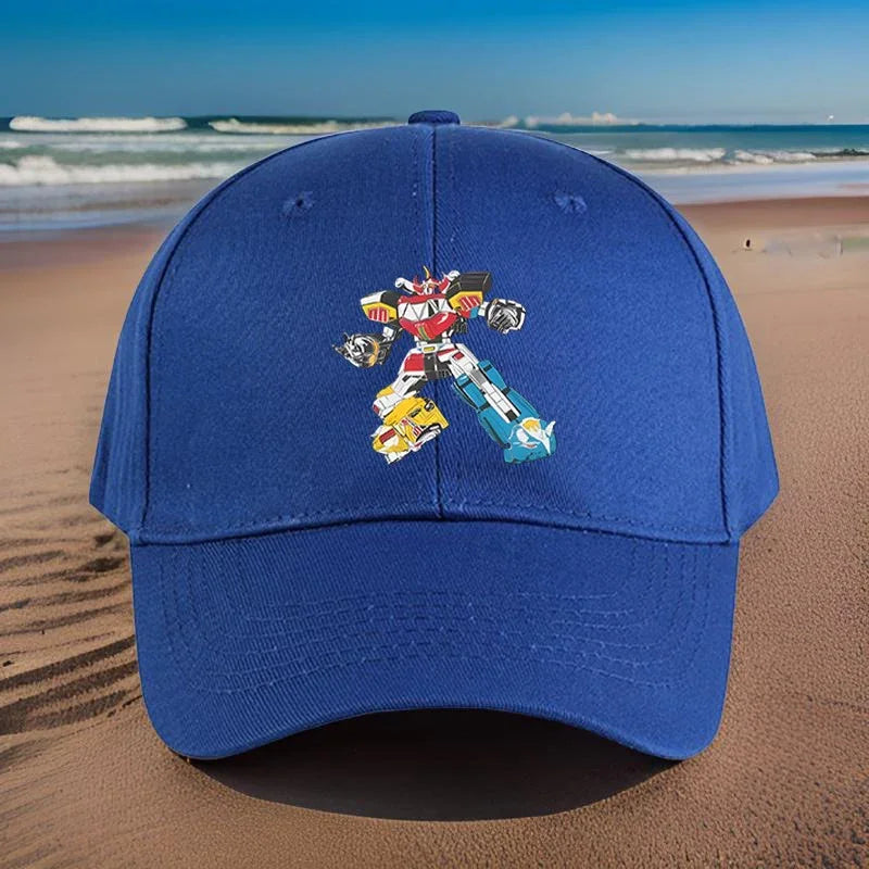 Casquette bleue avec motif robot coloré, posée sur une plage ensoleillée – Transformers.