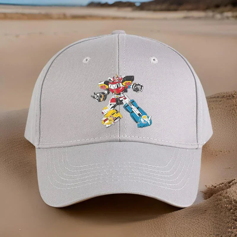 Casquette beige avec robot coloré dessiné au centre, posée sur du sable – Transformers.