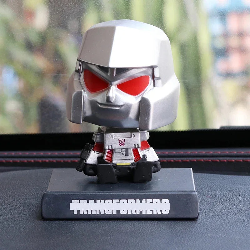 Figurine de Megatron argentée avec yeux rouges sur support noir à l’intérieur d’une voiture – Transformers.