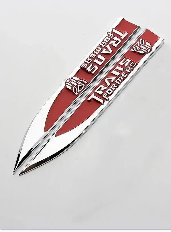 Deux emblèmes Transformers rouges et argentés, forme allongée, logo Autobot visible – Transformers.