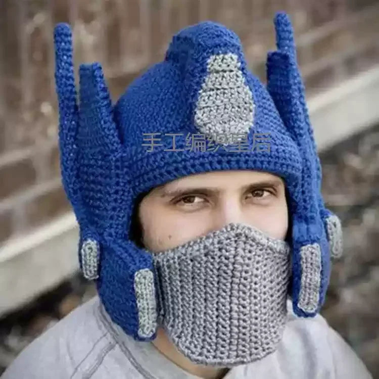 Bonnet tricoté bleu et gris style Optimus Prime porté par un homme, fond mur en briques – Transformers.