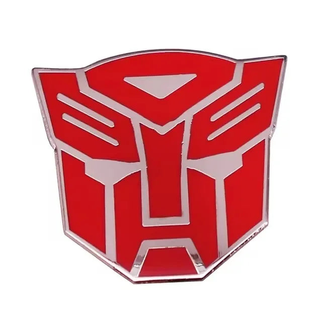 Badge logo Autobot rouge et argent en forme de tête stylisée sur fond blanc – Transformers.