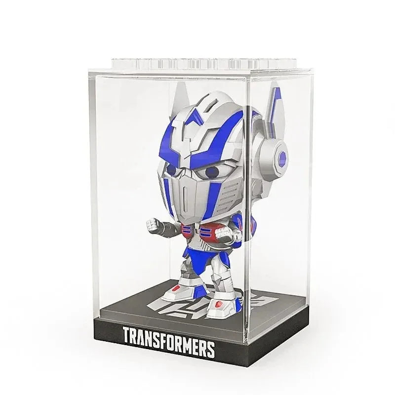 Figurine chibi Optimus Prime argentée et bleue sous vitrine, socle noir, style cartoon – Transformers.