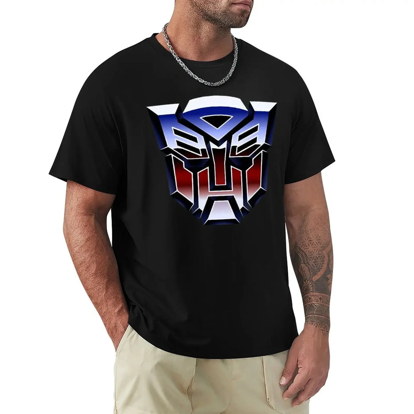 Homme portant un t-shirt noir avec logo Autobots bleu, rouge et argent sur fond uni – Transformers.