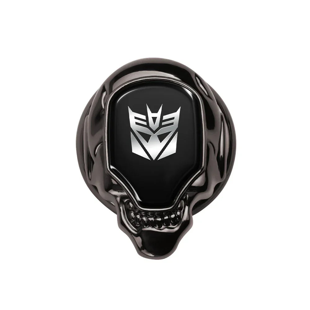 Bague noire tête de mort avec logo Decepticon argenté sur fond blanc – Transformers.