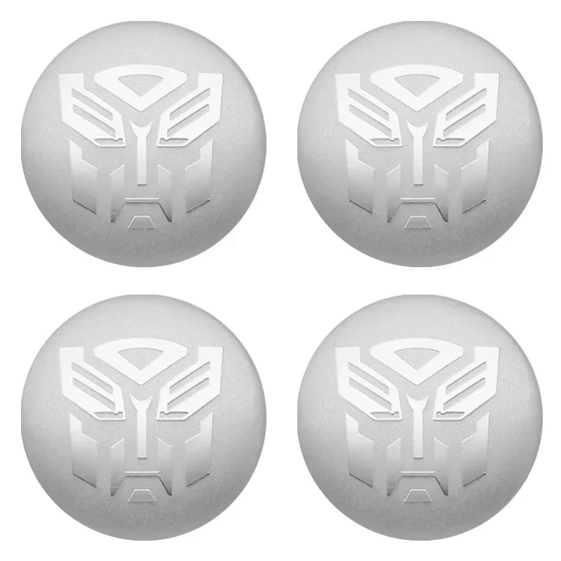 Set de quatre bouchons de valve argentés avec logo Autobot gravé, fond blanc – Transformers.
