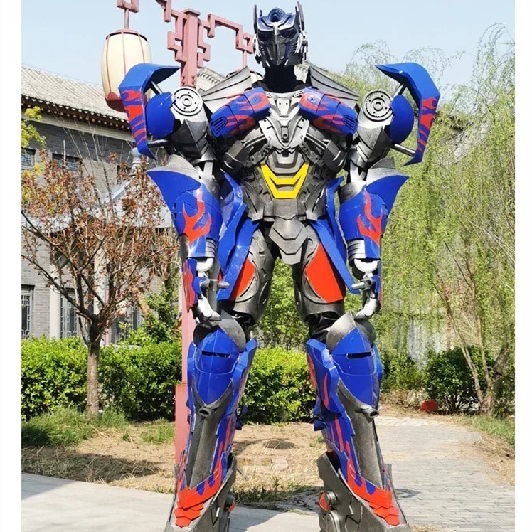 Statue robot bleu et rouge en armure stylisée, debout en extérieur, posture droite – Transformers.