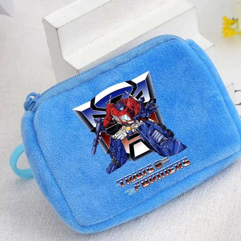 Trousse en peluche bleue avec Optimus Prime, logo métallique et texte coloré – Transformers.