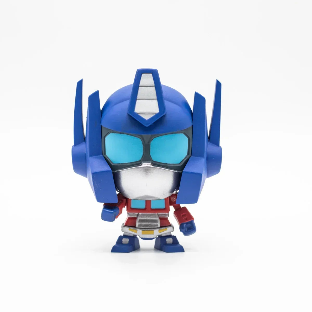 Figurine Optimus Prime stylisée, casque bleu et gris, pose debout sur fond blanc – Transformers.