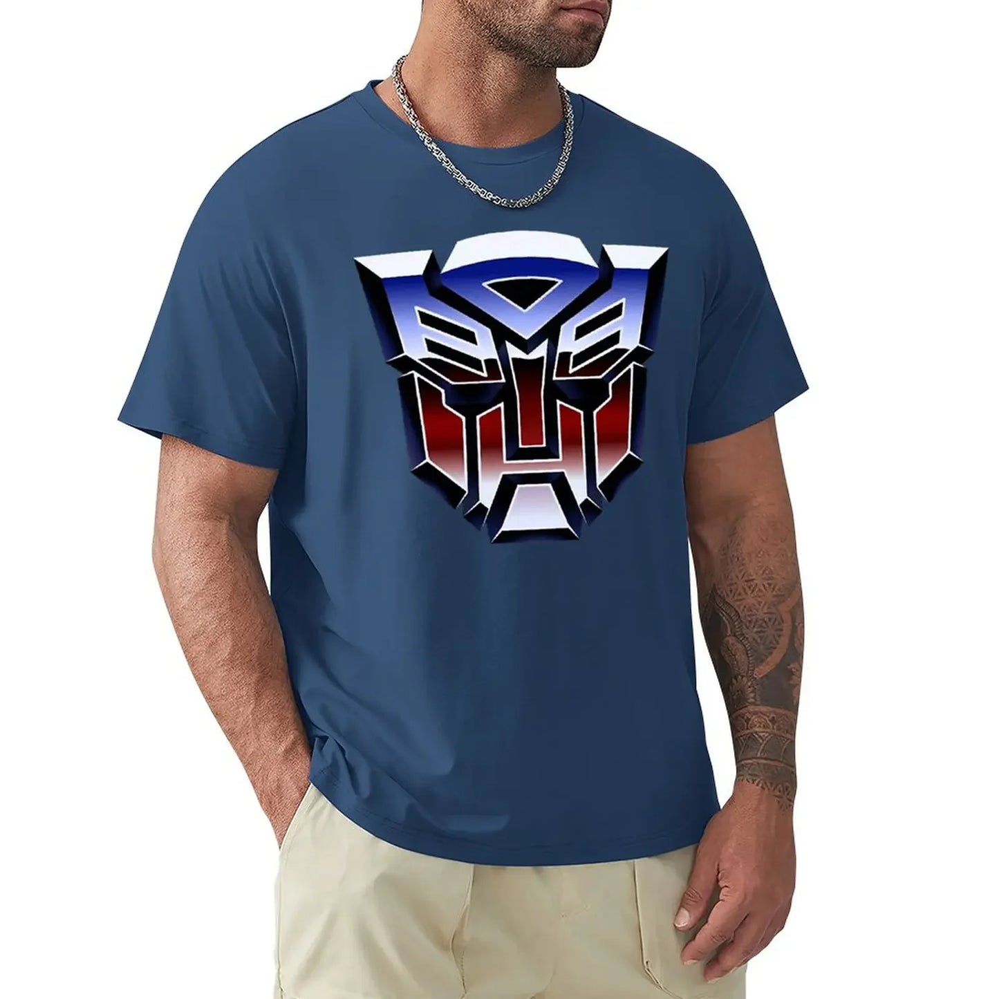Homme portant un t-shirt bleu avec logo Autobot coloré au centre sur fond blanc – Transformers.