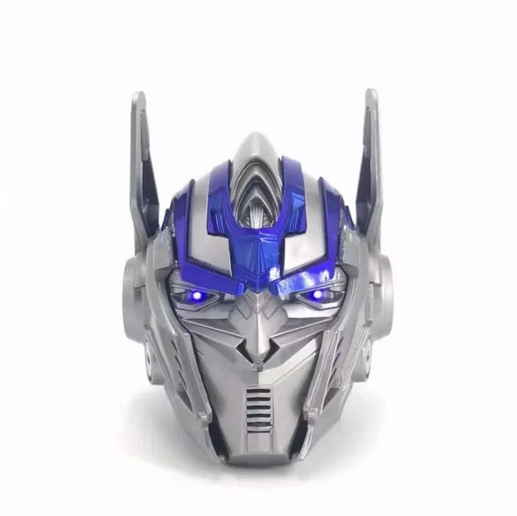 Masque de robot gris et bleu style Optimus Prime, yeux lumineux, sur fond blanc – Transformers.