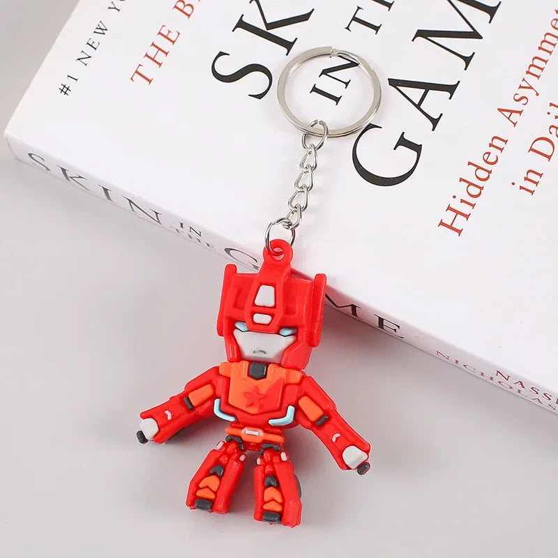 Porte-clés figurine robot rouge, personnage stylisé sur fond de livre blanc – Transformers.