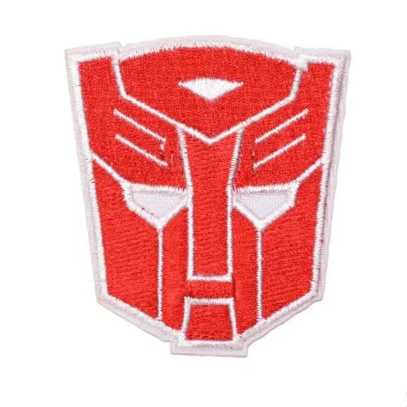 Écusson brodé rouge représentant le logo Autobot, forme de visage stylisé sur fond blanc – Transformers.