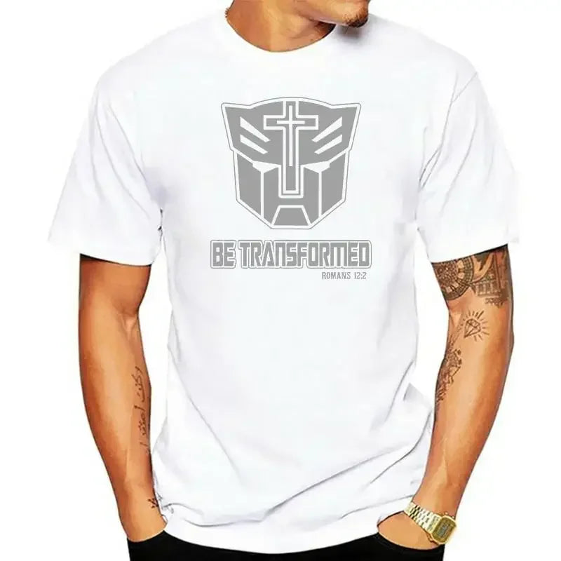 Homme portant un t-shirt blanc logo Transformers gris, croix chrétienne, texte Be Transformed – Transformers.