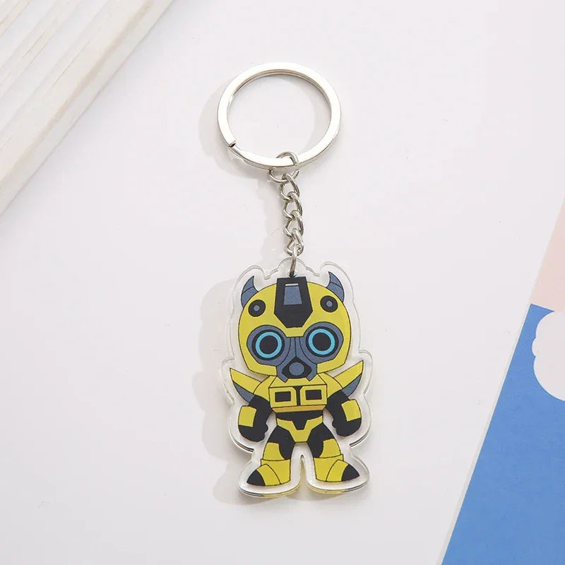 Porte-clés acrylique personnage jaune stylisé, costume robot, fond blanc coloré – Transformers.