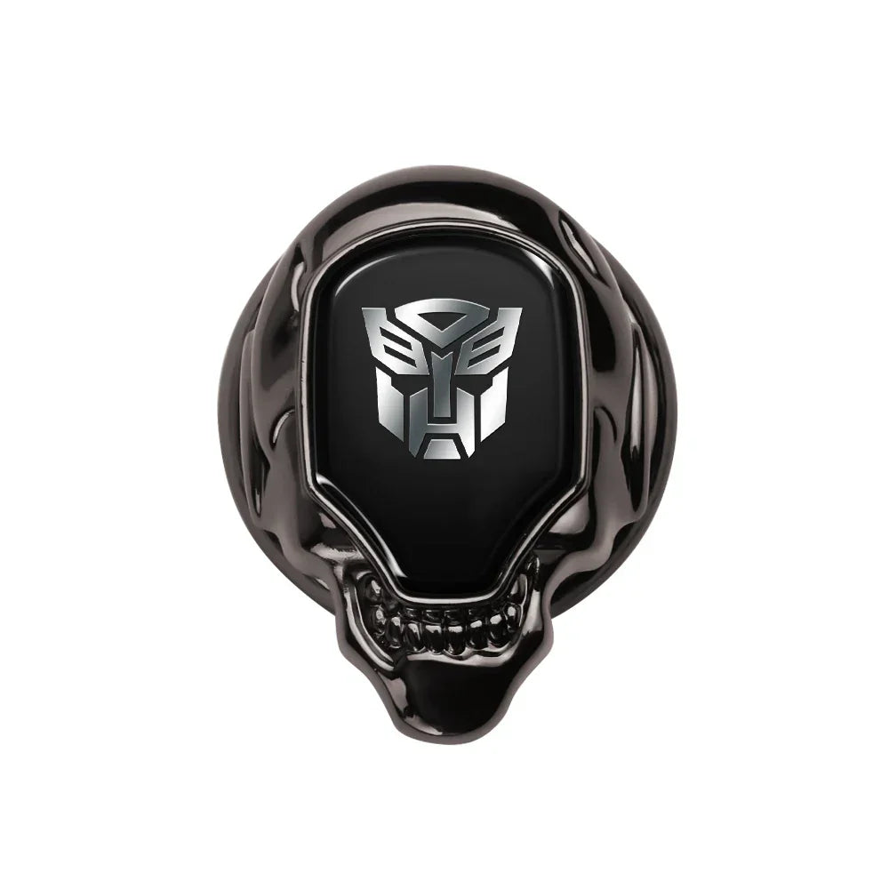 Bague noire tête de mort avec logo argenté Autobots sur fond blanc – Transformers.