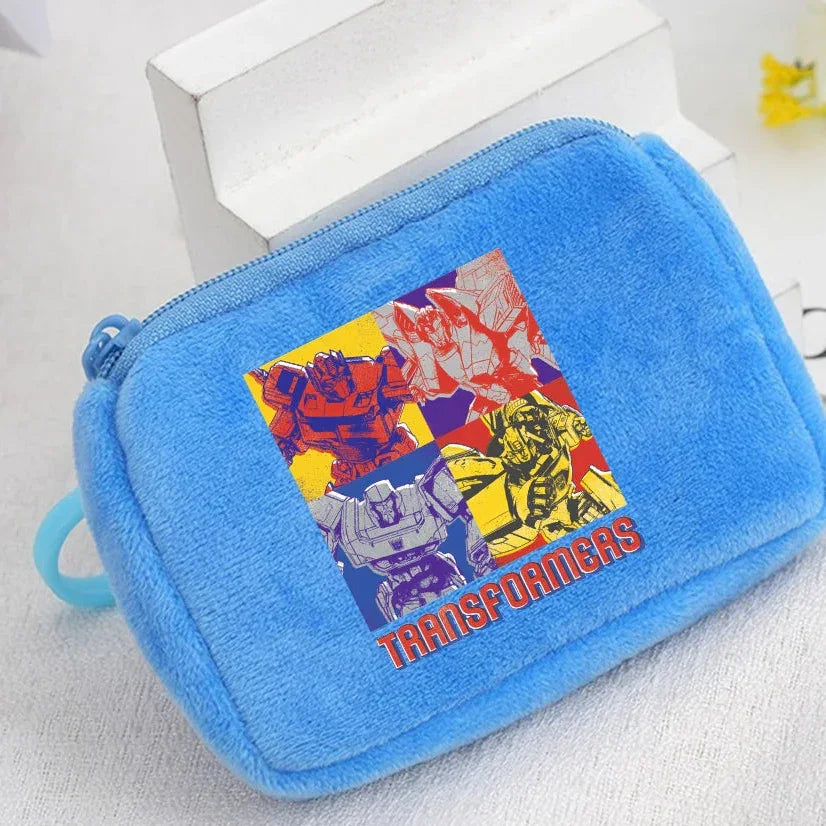 Pochette bleue en peluche avec illustration colorée de robots Transformers, style pop art – Transformers.