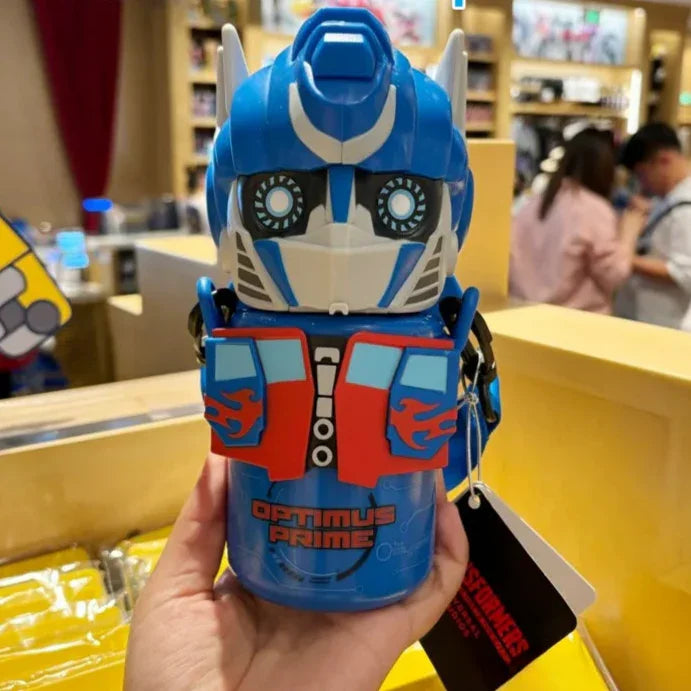 Bouteille isotherme Optimus Prime bleu et rouge tenue à la main, design robot détaillé – Transformers.