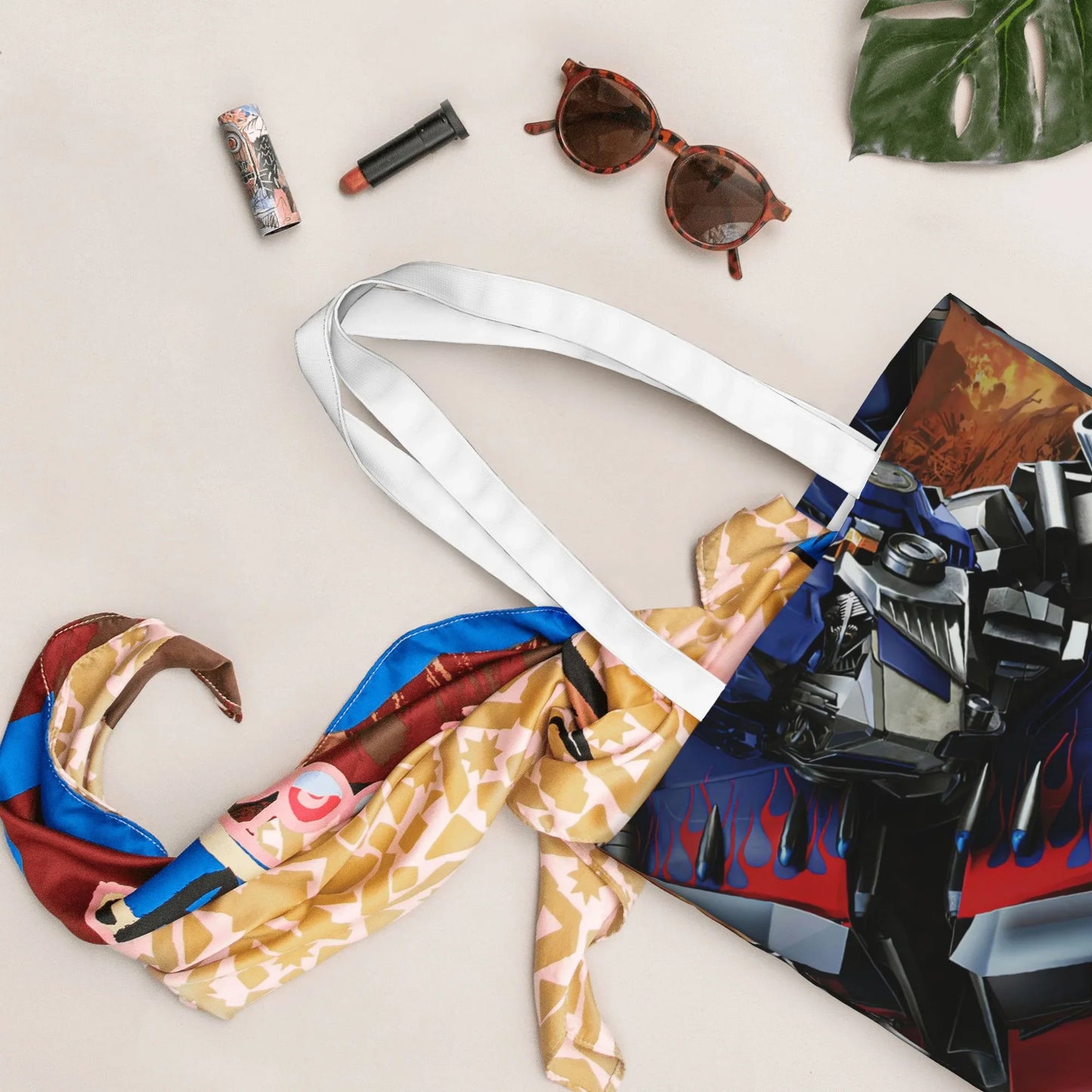 Sac cabas à motif Optimus Prime, foulard coloré, lunettes et maquillage sur fond beige – Transformers.