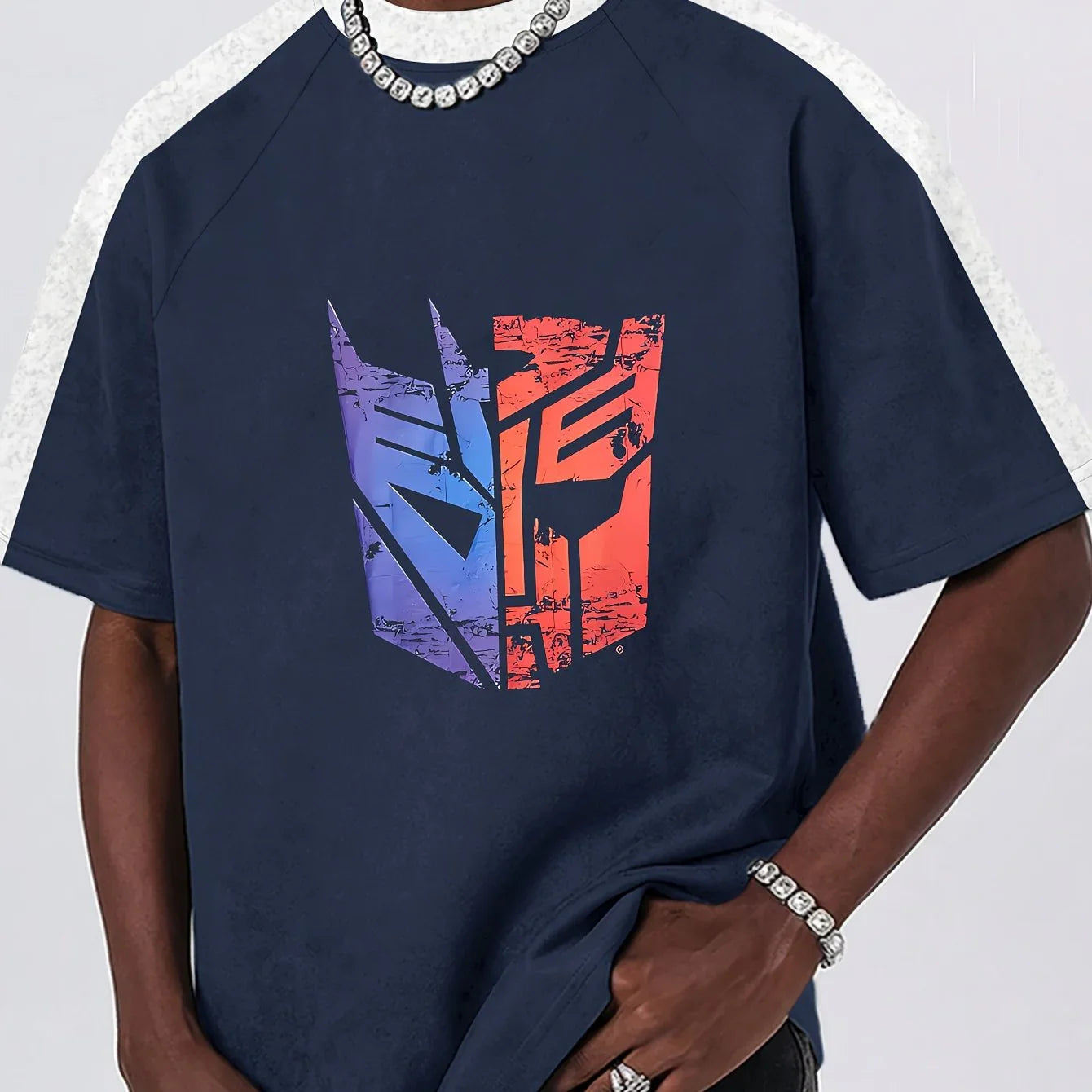 T-shirt bleu avec logo bicolore Transformers stylisé, porté par un homme, fond neutre – Transformers.