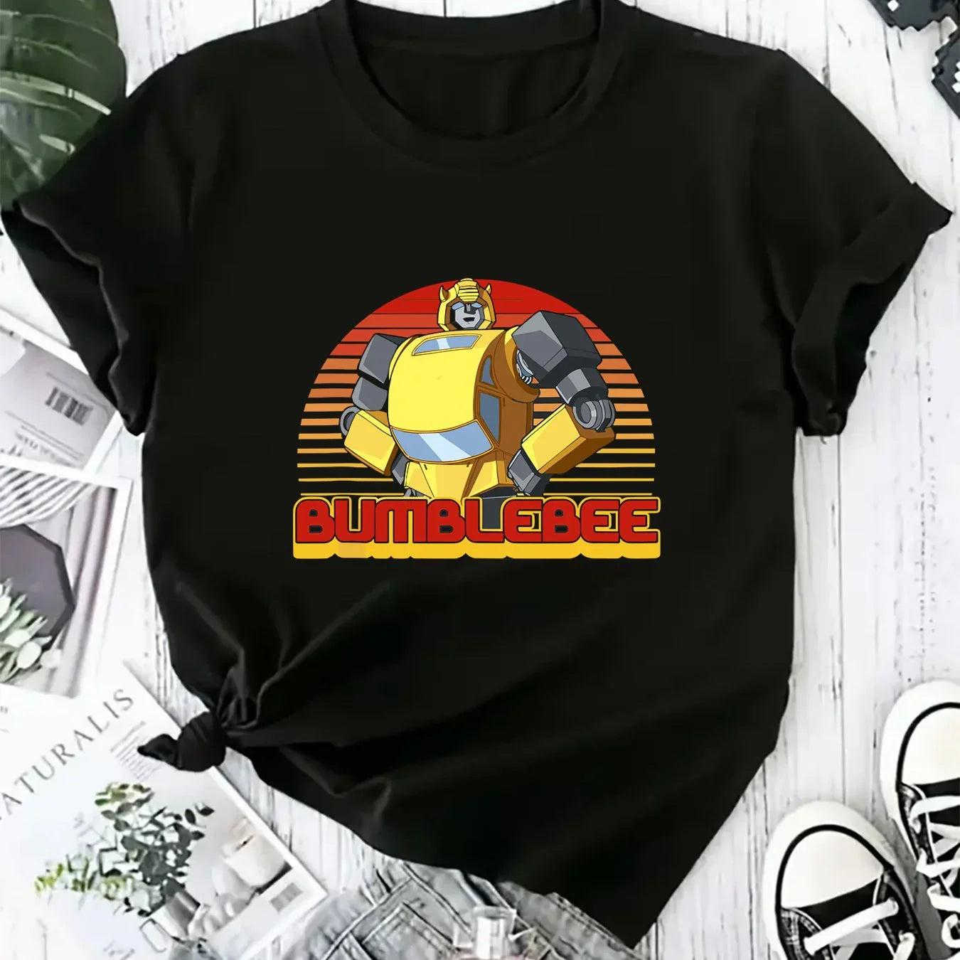 T-shirt noir avec dessin Bumblebee jaune, style rétro, fond rayé orange et rouge – Transformers.