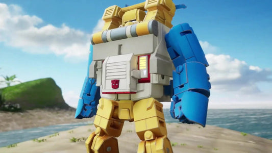 Jouet robot Transformers jaune et bleu, posture debout sur plage, ciel bleu en arrière-plan – Transformers.